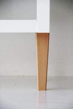 a white table with a wooden leg on it