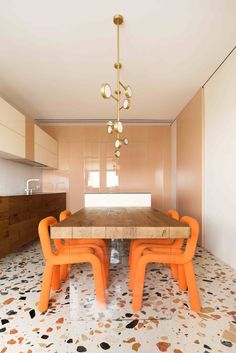 an orange table and chairs are in the middle of a room with tile flooring