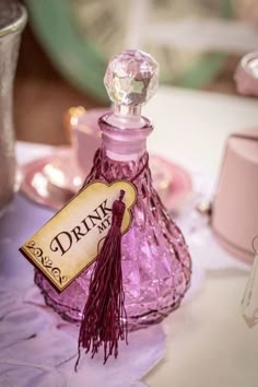 a bottle of pink perfume sitting on top of a table