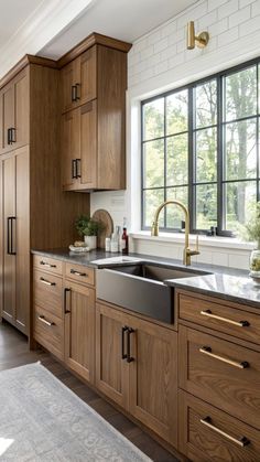 a kitchen with wooden cabinets and stainless steel sink in the center, along with an area rug on the floor