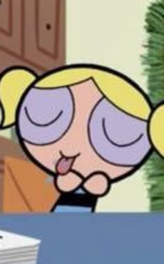 a cartoon character with blonde hair sitting at a desk in front of a computer monitor