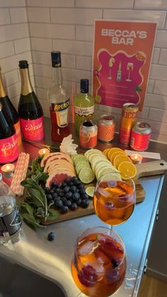 a table topped with wine glasses filled with different types of drinks and food on top of it