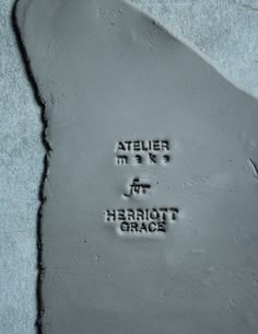 a close up of a piece of cement with writing on it that says atelier me and heriott grace