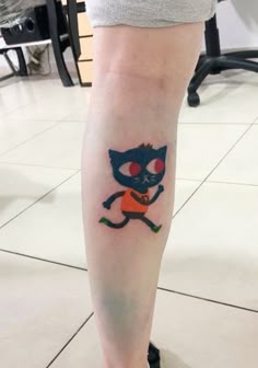 a person with a cat tattoo on their leg