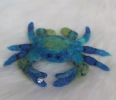 a blue and green crab on white fur