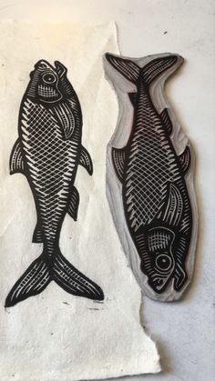 two black and white fish on paper next to each other, one is cut in half