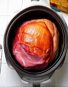 an open crock pot filled with meat on top of a white tile countertop