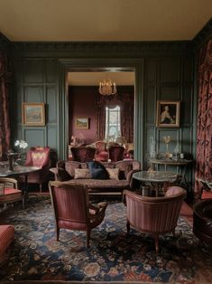 a living room filled with lots of furniture next to a fire place and chandelier