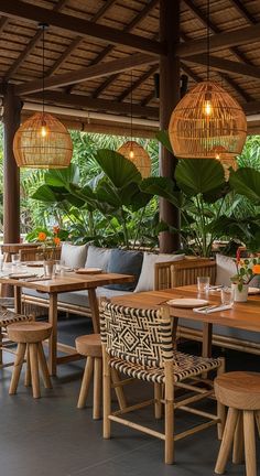 an outdoor dining area with wooden tables and wicker lamps hanging from the rafters
