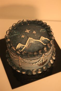 a cake with mountains and stars on it sitting on top of a black boarder