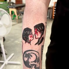 a person with a tattoo on their arm has a skull and two women's faces
