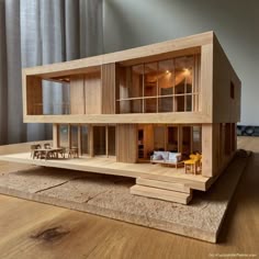 a wooden model of a house with windows and balconies on top of it
