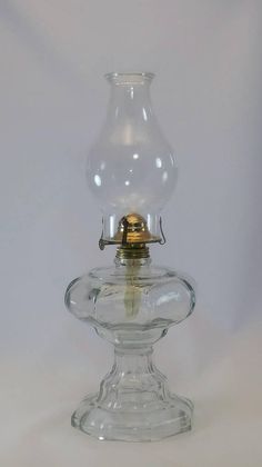 a clear glass vase with a gold lid