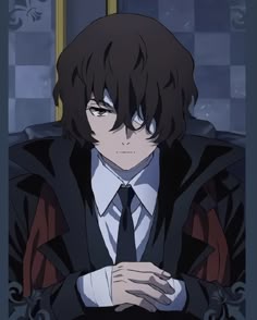 a man in a suit and tie with his hands folded over his chest, staring at the camera