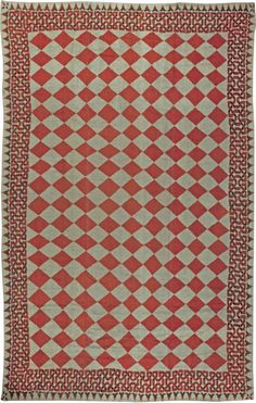 an old red and white rug with diamonds on it