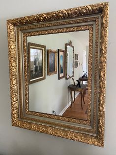 an ornate gold framed mirror hanging on the wall