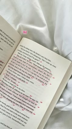 an open book sitting on top of a bed