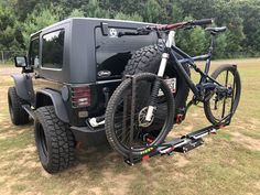 a black jeep with a bike strapped to the back