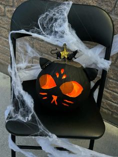 a black chair with a pumpkin decorated like a cat