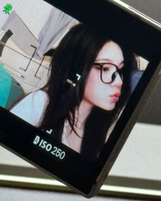 a woman with glasses is looking at the camera