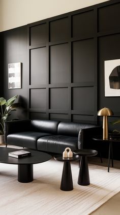 a living room with black leather furniture and white rugs on the floor in front of a wall