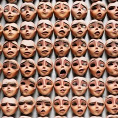many faces are arranged in rows on the wall
