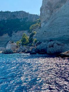 the water is crystal blue and there are some cliffs in the backgrouds