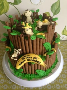 a birthday cake made to look like a tree stump with monkeys and bananas on top