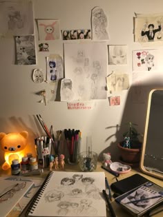 the desk is cluttered with drawings and other items