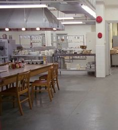 an industrial kitchen with lots of tables and chairs