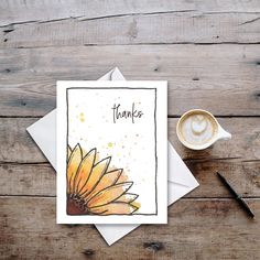 a thank card with an orange sunflower on it next to a cup of coffee