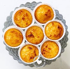 twelve muffins in paper cups sitting on a metal platter, top view