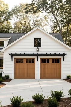 a white house with two brown garage doors