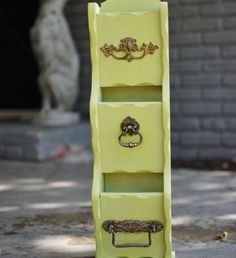 a yellow shelf with three drawers on it