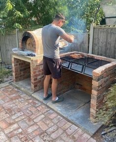 a man standing in front of an outdoor grill