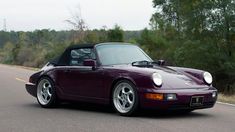 a purple sports car driving down the road