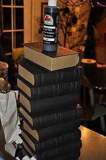 a stack of books sitting on top of each other in front of a glass vase