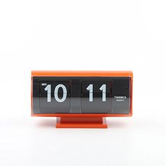 an orange and black clock with the time 11 10 on it's display stand