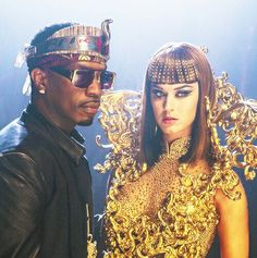 a man standing next to a woman dressed in gold and wearing an elaborate headdress