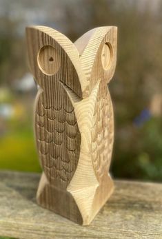 a carved wooden owl sitting on top of a wooden bench
