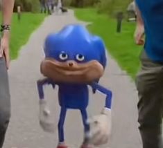 two people walking down a sidewalk with a blue object on it's head and legs