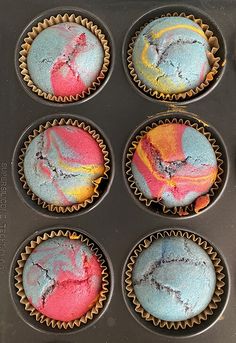 six colorful cupcakes in a muffin tin