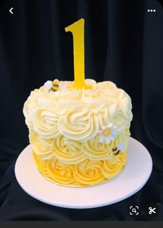 a yellow cake with white frosting and a number one on top
