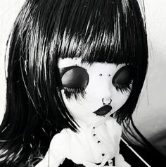 a black and white photo of a doll with long hair