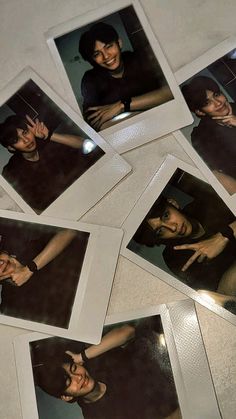 several polaroid pictures of people making faces on the table with their hands in the air