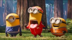 three minions from despicable me standing in the grass with one holding a balloon