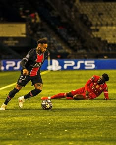 two soccer players are on the field during a game, one is falling to the ground