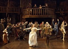 a group of people standing on top of a wooden floor in front of a crowd