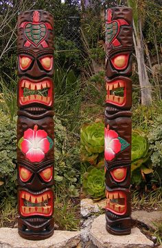 two wooden tiki statues sitting next to each other on top of a stone slab