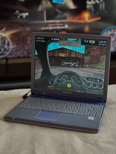 an open laptop computer sitting on top of a bed